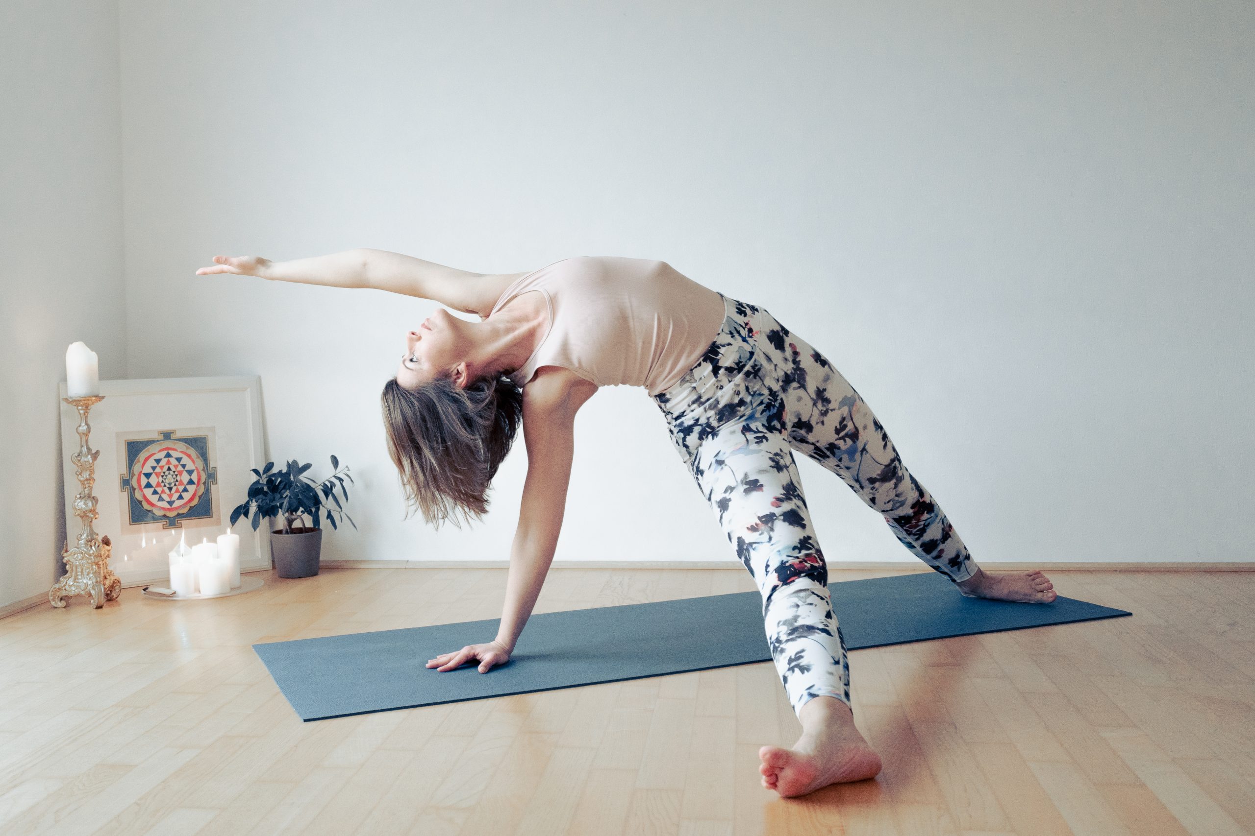 Eine Person in einer Yoga- Pose vor einem weißen Hintergrund.